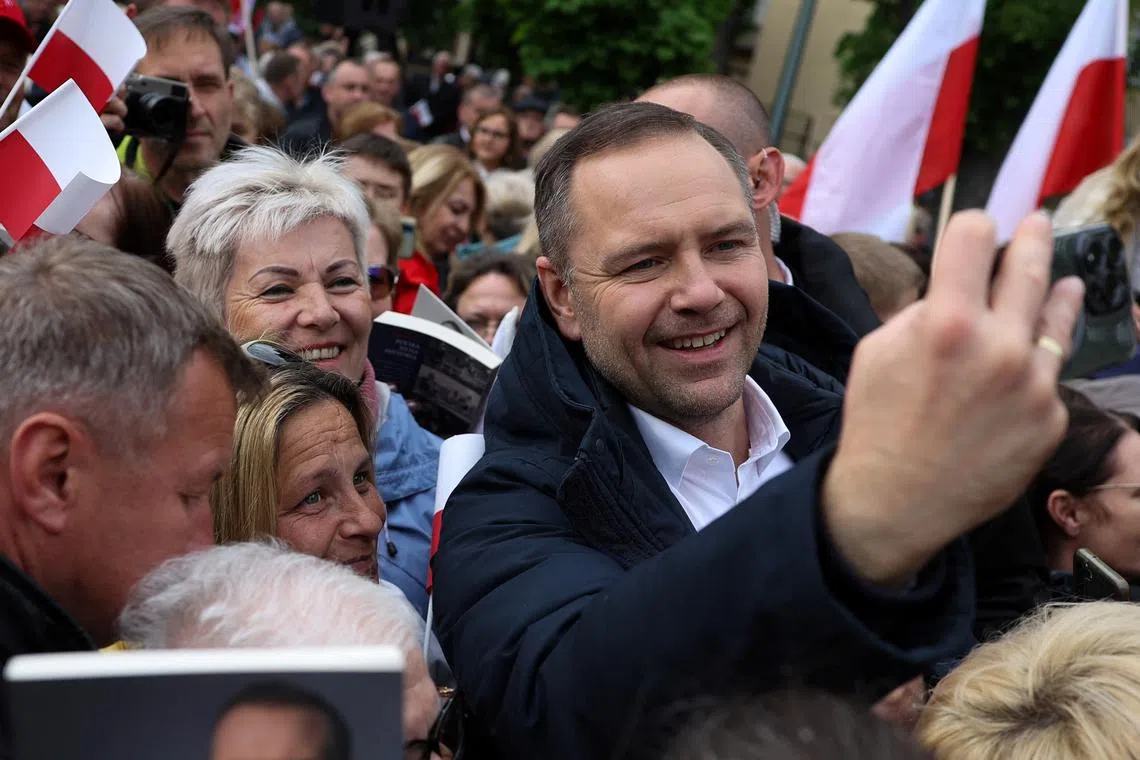 Karol Nawrocki, Polish presidential election candidate supported by the main opposition party Law and Justice (PiS), takes a selfie with supporters at a campaign meeting in Garwolin, Poland, May 5, 2025. REUTERS/Kacper Pempel/File Photo