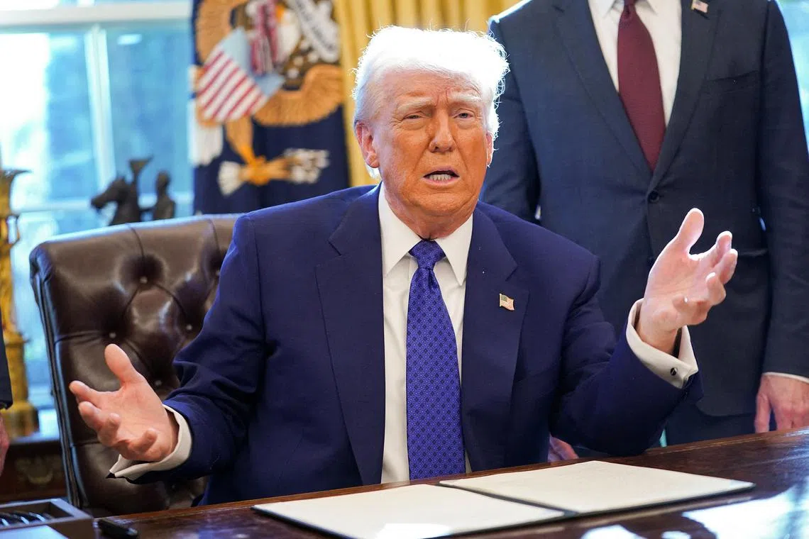 U.S. President Donald Trump speaks, as he sits to sign an executive order, in the Oval Office, at the White House in Washington, D.C., U.S. February 14, 2025.  REUTERS/Nathan Howard/File Photo