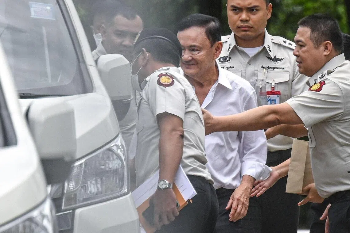 TOPSHOT - Thailand's former Prime Minister Thaksin Shinawatra (C) is escorted into a police van outside the Supreme Court in Bangkok on September 9, 2025, after he was sentenced to a year in prison. Thailand's Supreme Court ordered on September 9, that former prime minister Thaksin Shinawatra be taken to jail immediately to serve one year behind bars, after ruling his 2023 prison term was incorrectly served. (Photo by Panumas SANGUANWONG / THAI NEWS PIX / AFP)