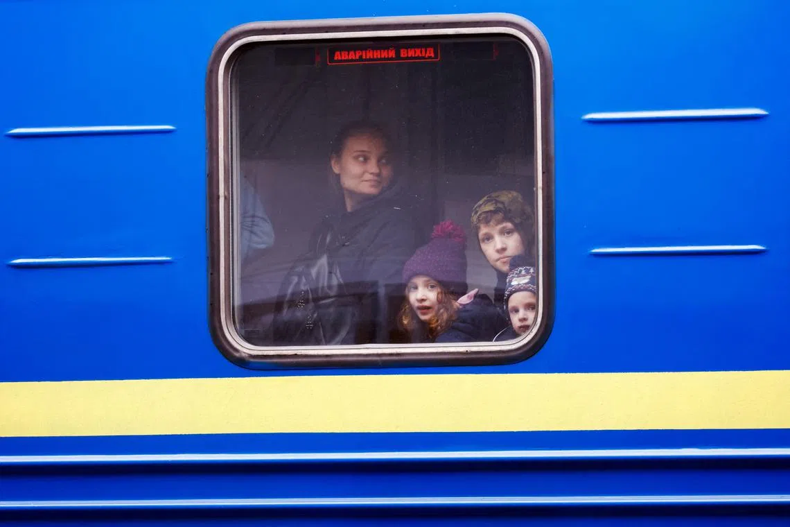 FILE PHOTO: Ukrainian refugees look out of a window on a train arriving from Odesa after crossing the Ukraine-Poland border, amid the Russian invasion of Ukraine, at Przemysl Glowny train station in Przemysl, Poland, April 21, 2022.