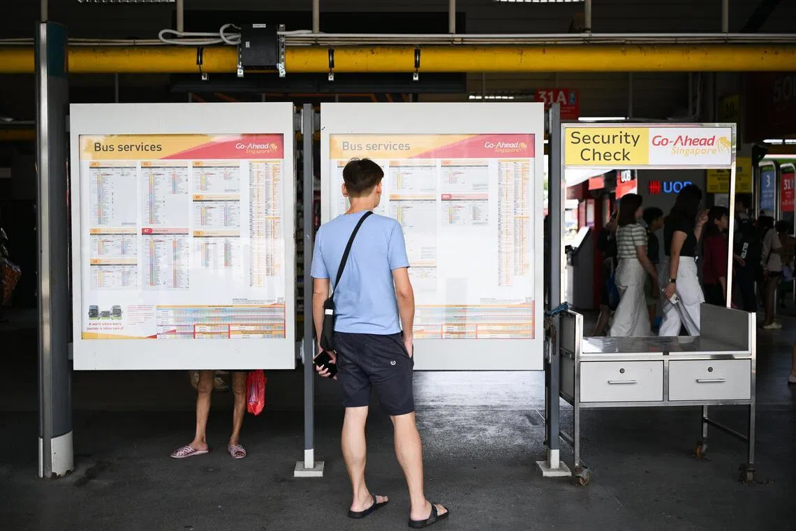 Passengers looking at bus services information at Tampines Bus Interchange on July 7.