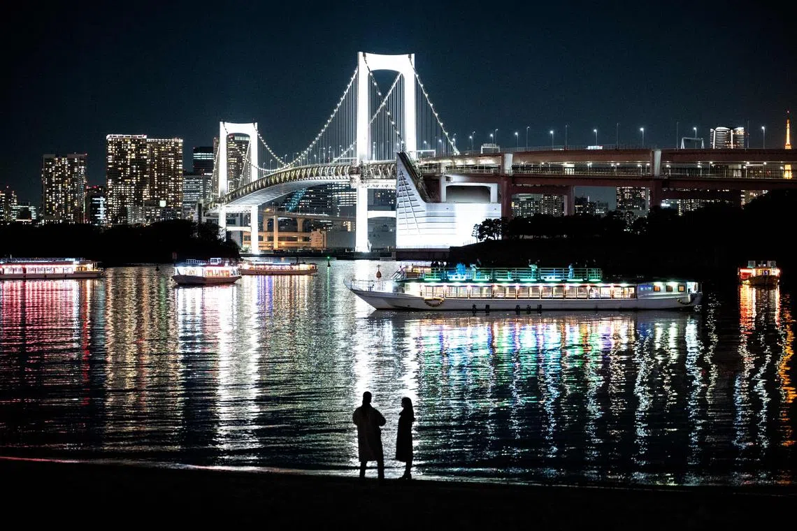 People standing along the beach at Odaiba Marine Park in Tokyo on Dec 10, 2024. 
