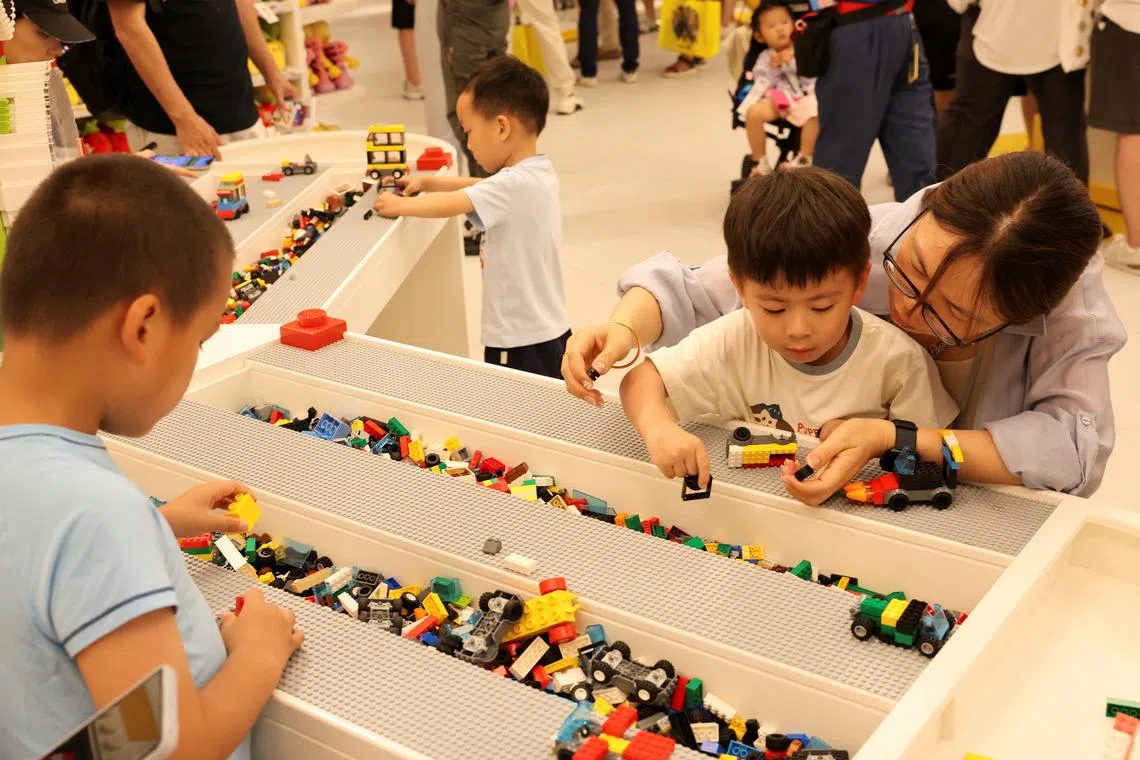 Children build Lego toys in a gift shop of Legoland Shanghai Resort on its opening day on July 5.