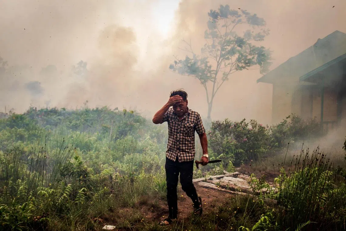 epa07860681 A resident runs away as fire gets closer to his house in Palangkaraya, Central Kalimantan, Indonesia, 22 September 2019. Firefighters, military personnel and water-dropping helicopters are deployed to douse the land fires in Sumatra and Borneo that caused thick haze in the neighboring countries, Singapore and Malaysia.  EPA-EFE/FULLY HANDOKO