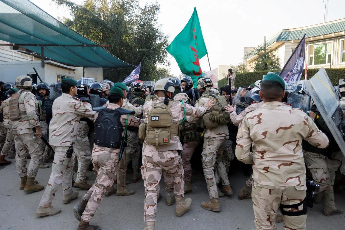 Iraqi security forces push back demonstrators during a protest  outside the Swedish embassy in Baghdad, on Jan 23, 2023.