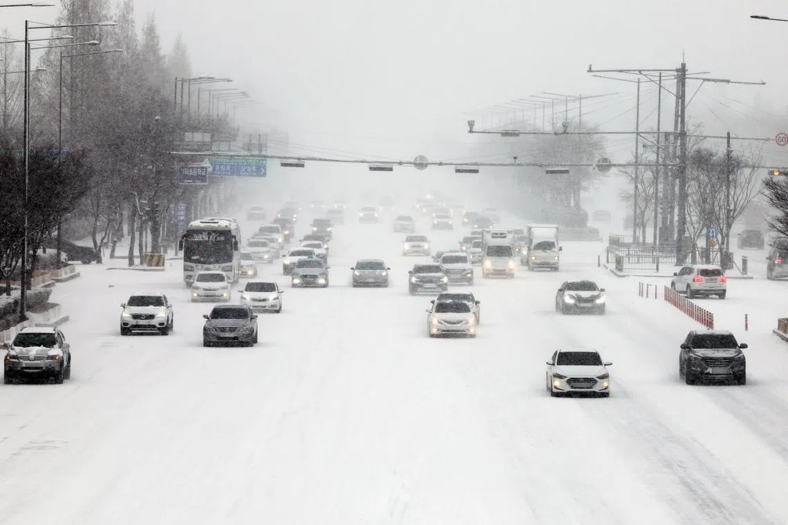epaselect epa10425816 Cars move slowly on a road amid heavy snowfall in Gwangju, South Korea, 24 January 2023, the last day of the four-day Lunar New Year holiday.  EPA-EFE/YONHAP SOUTH KOREA OUT