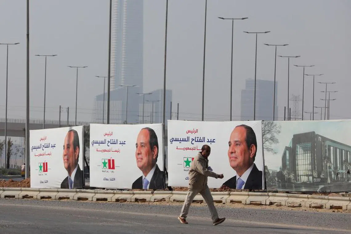 An Egyptian man walks next to a banner of presidential candidate and current Egyptian President Abdel Fattah al-Sisi at the New Administrative Capital (NAC), east of Cairo, Egypt, December 12, 2023. REUTERS/Mohamed Abd El Ghany/File Photo