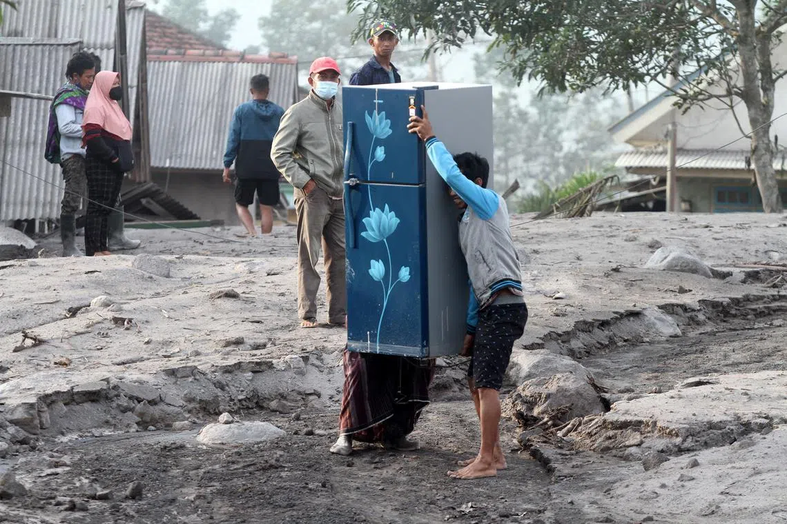 Villagers salvage a refrigerator from an area affected by the eruption of Mount Semeru volcano, in Lumajang, East Java province, Indonesia, Dec 5, 2022, in this photo taken by Antara Foto.