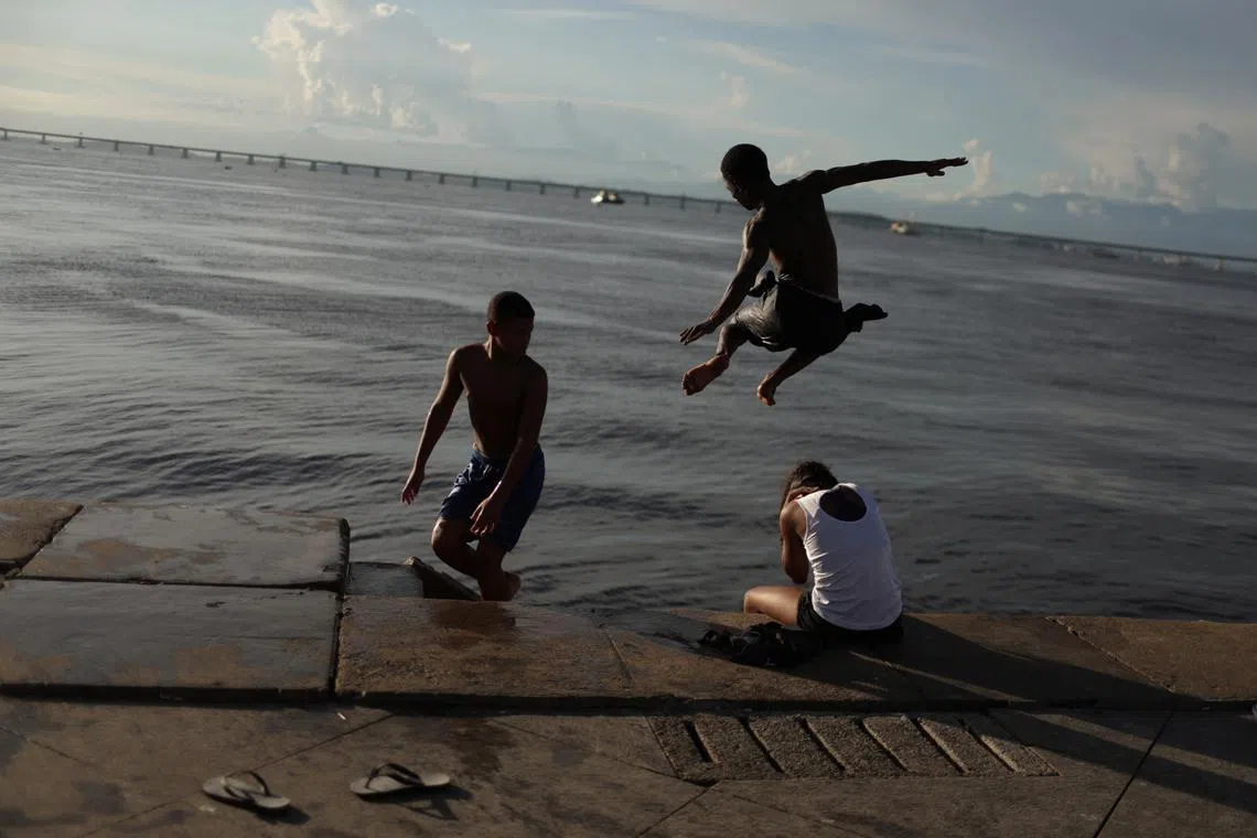 Boys diving into Guanabara Bay at Maua square in Rio de Janeiro, Brazil May 1, 2023. 
