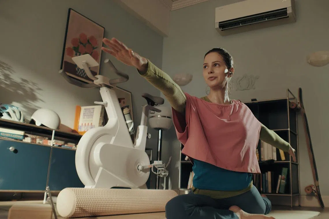 Woman doing yoga at home enjoying cool air from Samsung’s Bespoke AI WindFree Pro air-conditioner