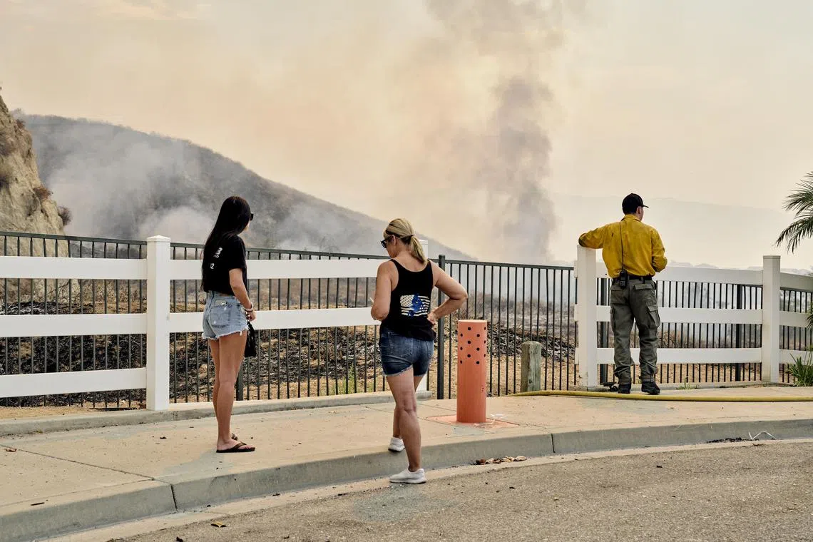 Residents watch a fire known as the Line fire from Highland., Calif., on Sunday, Sept. 8, 2024. An uncontrolled wildfire in Southern California threatened thousands of homes and businesses on Sunday, after quadrupling in size Saturday to over 17,000 acres and forcing mandatory evacuation orders for over 11,000 people. (Philip Cheung/The New York Times)