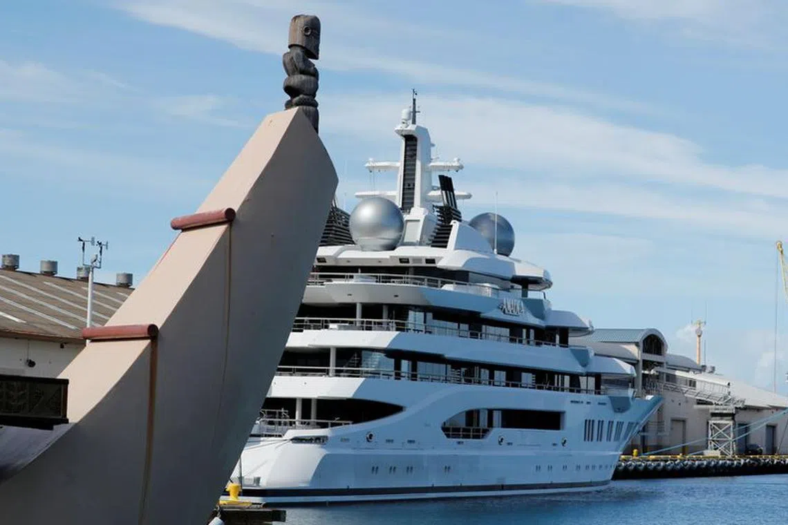 FILE PHOTO: Part of a Hawaii themed cruise ship is seen near the Russian-owned super yacht Amadea, which was seized in Fiji by American law enforcement, while it is docked in Honolulu, Hawaii, U.S. June 17, 2022. REUTERS/Marco Garcia/File Photo