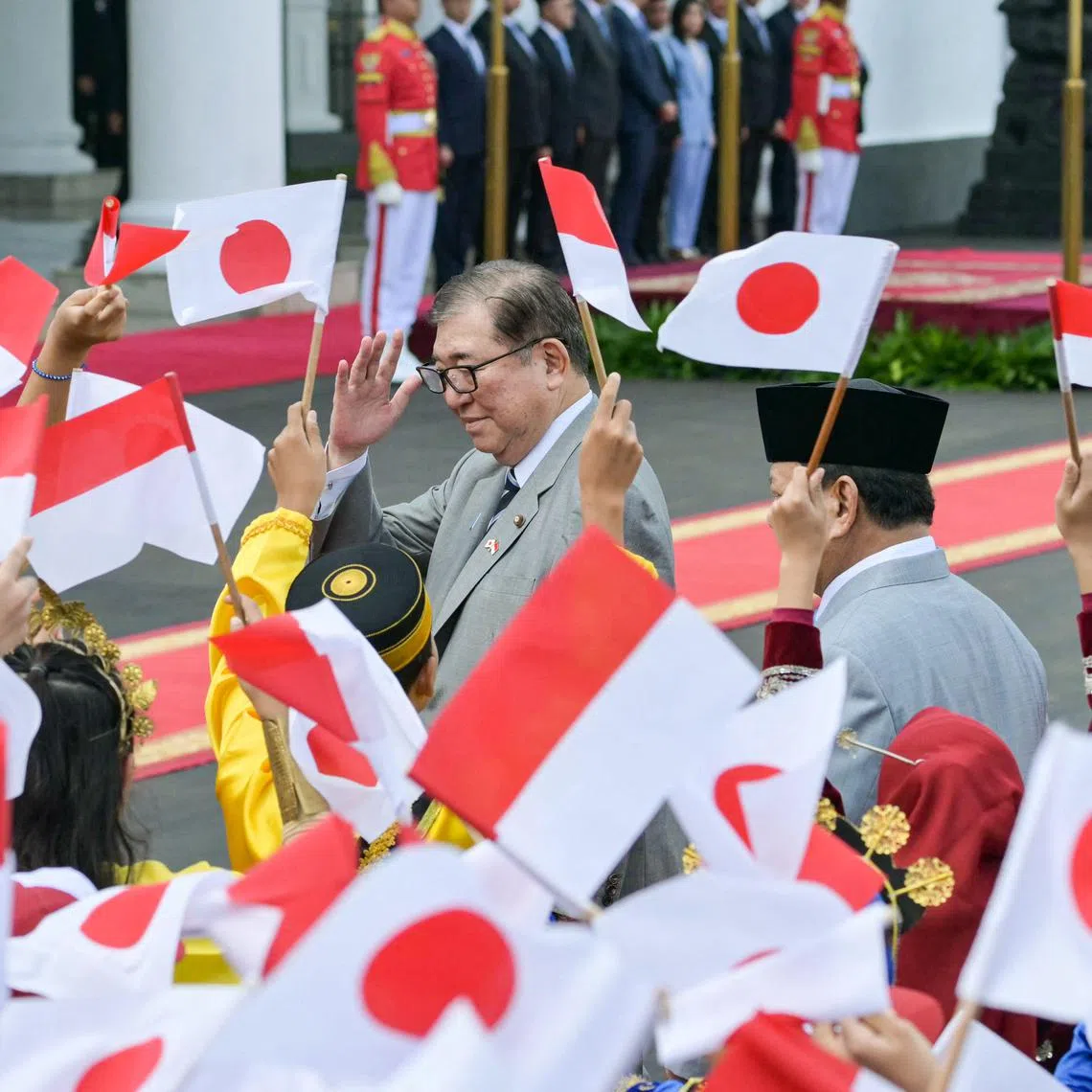 Indonesia's President Prabowo Subianto (R) receives Japan's Prime Minister Shigeru Ishiba during a ceremonial welcome at the presidential palace in Bogor, West Java, on January 11, 2025.