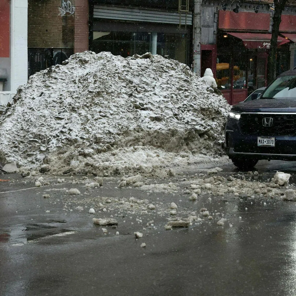 A man shovels a pile of snow from the recent snowatorm ahead of a new major winter storm in New York, on Feb 22.