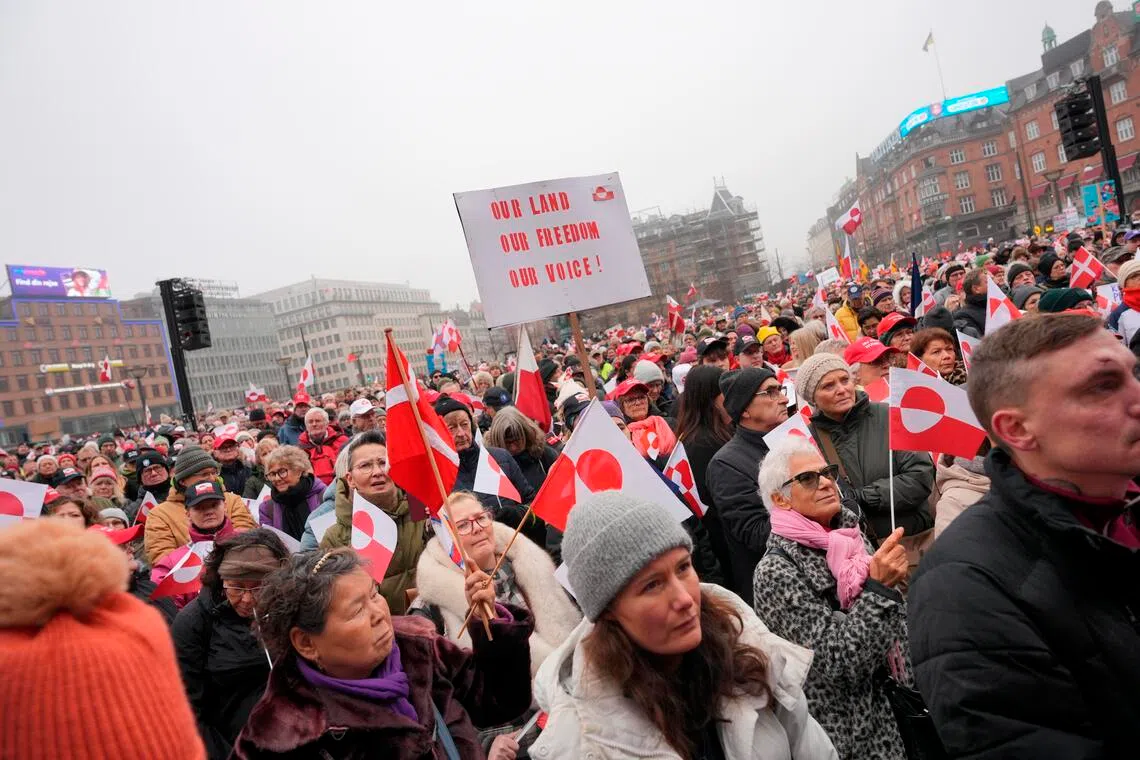 Waving the flags of Denmark and Greenland, the protesters formed a sea of red and white outside Copenhagen city hall.
