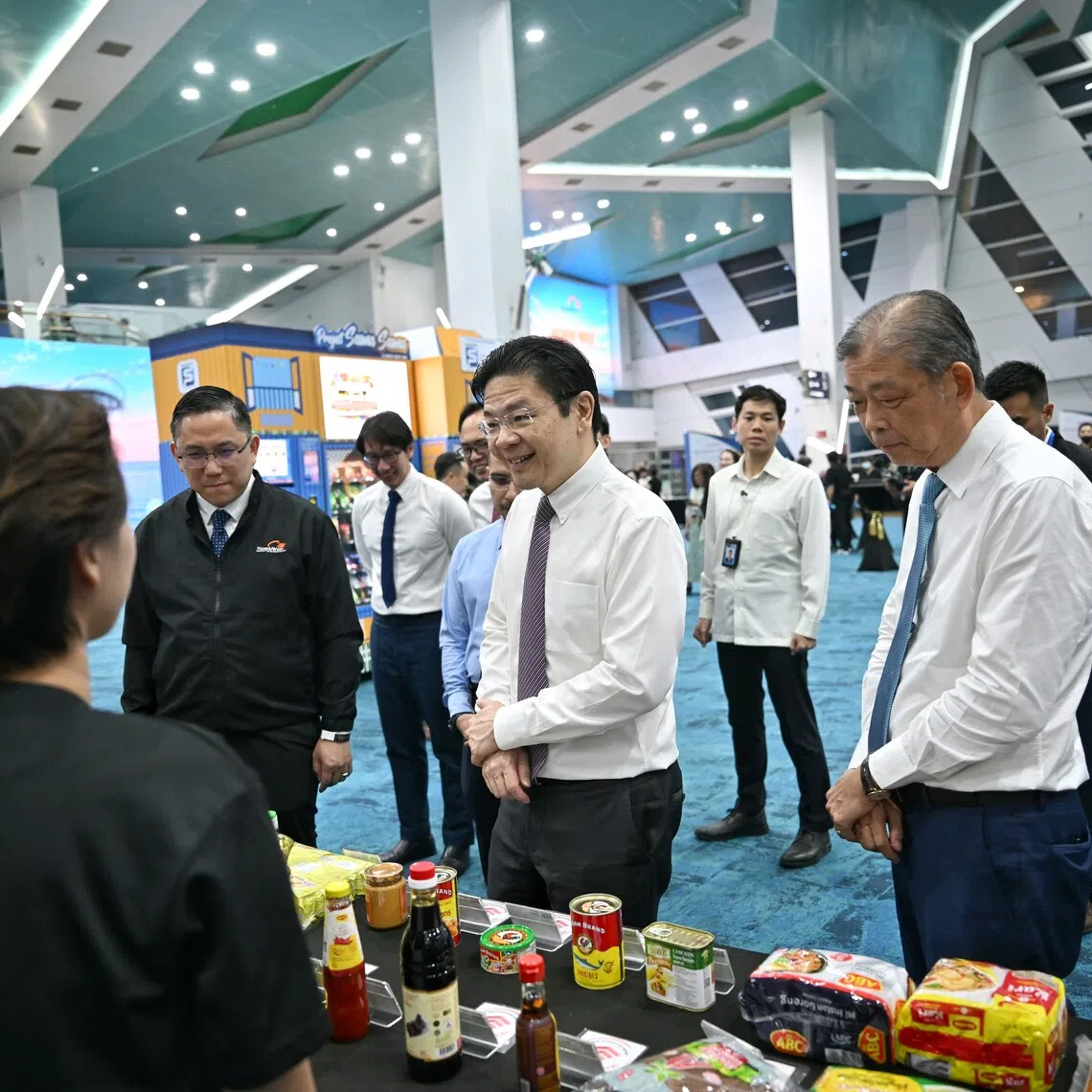 Prime Minister Lawrence Wong (centre) and North West District mayor Alex Yam (left) at an event marking the appointment of 62 district councillors to North West CDC’s 10th council term.