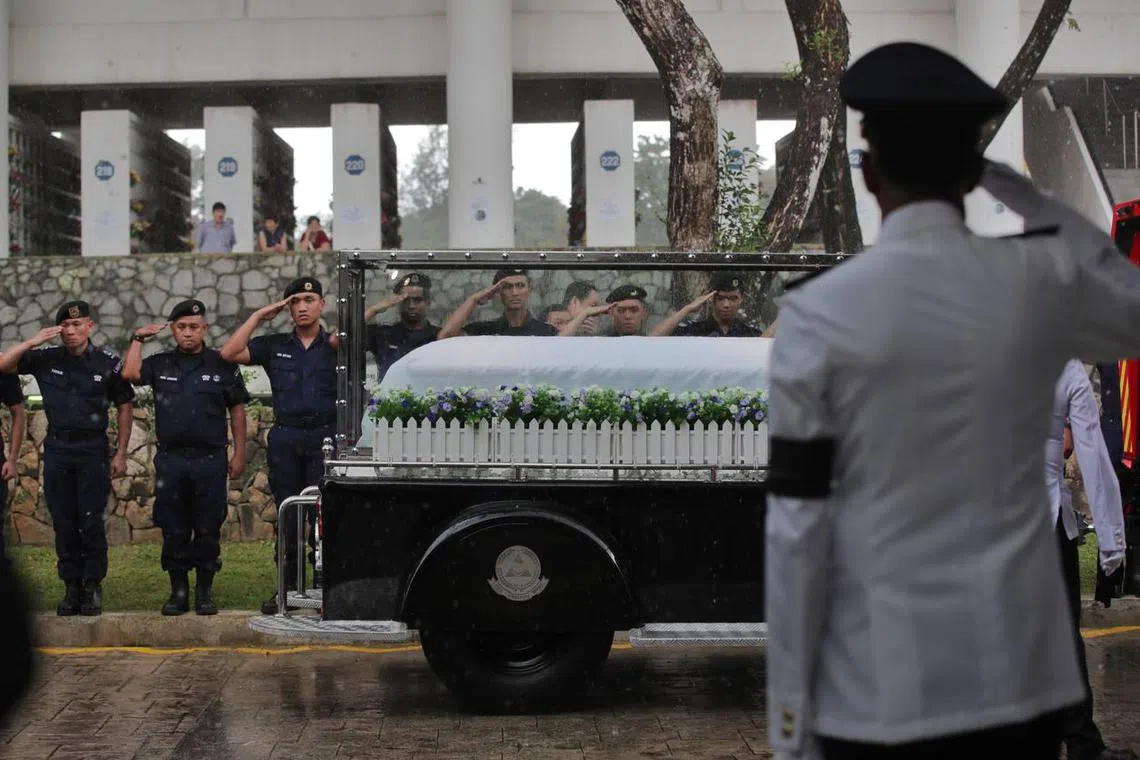 A contingent of SCDF officers saluting the hearse as it approached the service hall at Mandai.