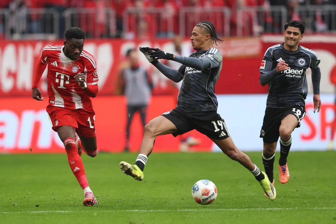 Soccer Football - Bundesliga - Bayern Munich v Eintracht Frankfurt - Allianz Arena, Munich, Germany - February 21, 2026 Bayern Munich's Alphonso Davies in action with Eintracht Frankfurt's Jean-Matteo Bahoya REUTERS/Maryam Majd
