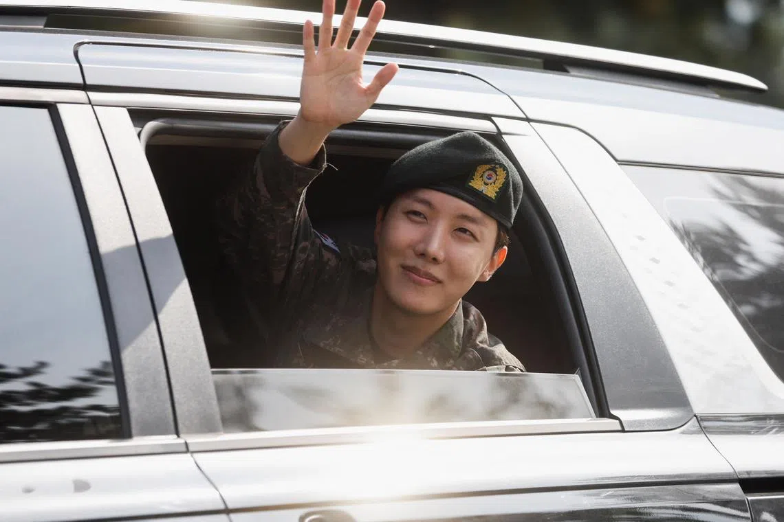 K-pop boy band BTS member J-Hope waves from inside a vehicle after being discharged from his 18 months of mandatory military service outside a military base in Wonju, South Korea, October 17, 2024. REUTERS/Kim Soo-hyeon