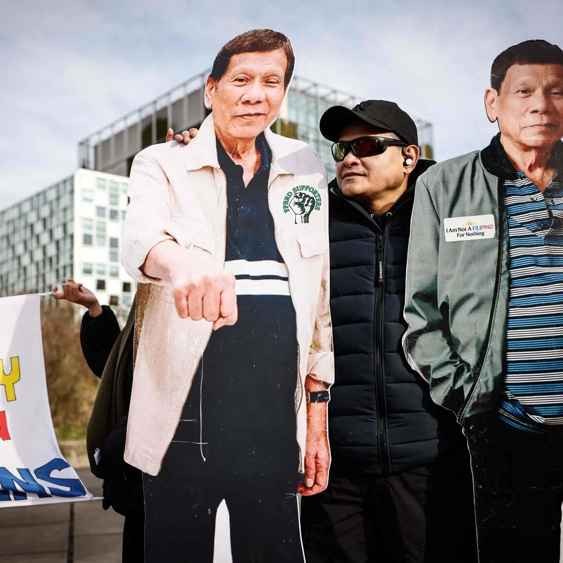 A person stands by two life-size cutouts of former Philippines' president Rodrigo Duterte during a demonstration in his support outside the International Criminal Court (ICC) on Feb 23, 2026.