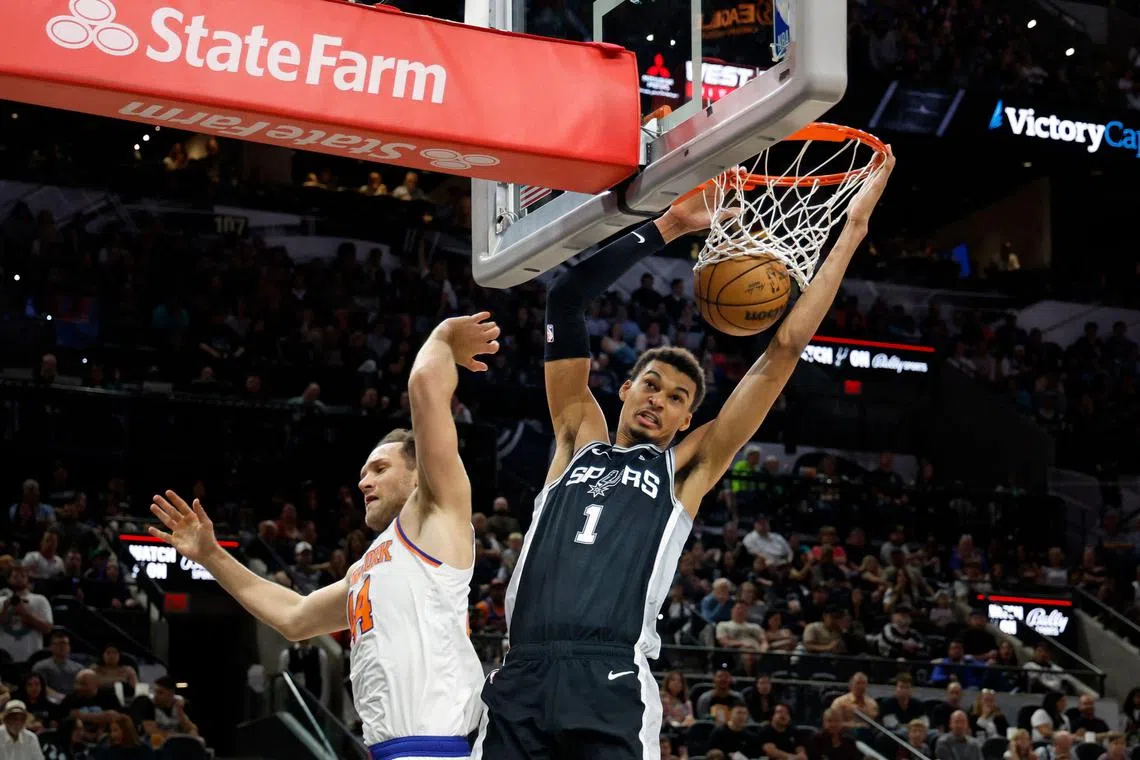 Victor Wembanyama of the San Antonio Spurs dunking over Bojan Bogdanovic of the New York Knicks in the first half of their 130-126 win at Frost Bank Centre on March 29. Wembanyama became the first rookie to record a 40-point, 20-rebound game since Shaquille O’Neal had 46 and 21 in 1993.