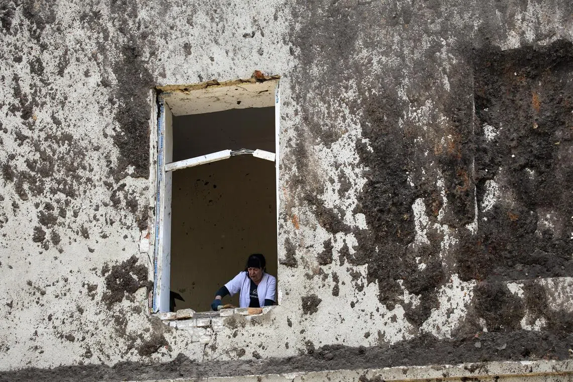 A medical worker clearing debris following a rocket attack on a psychiatric hospital in Kharkiv, northeastern Ukraine, on April 27, 2024.