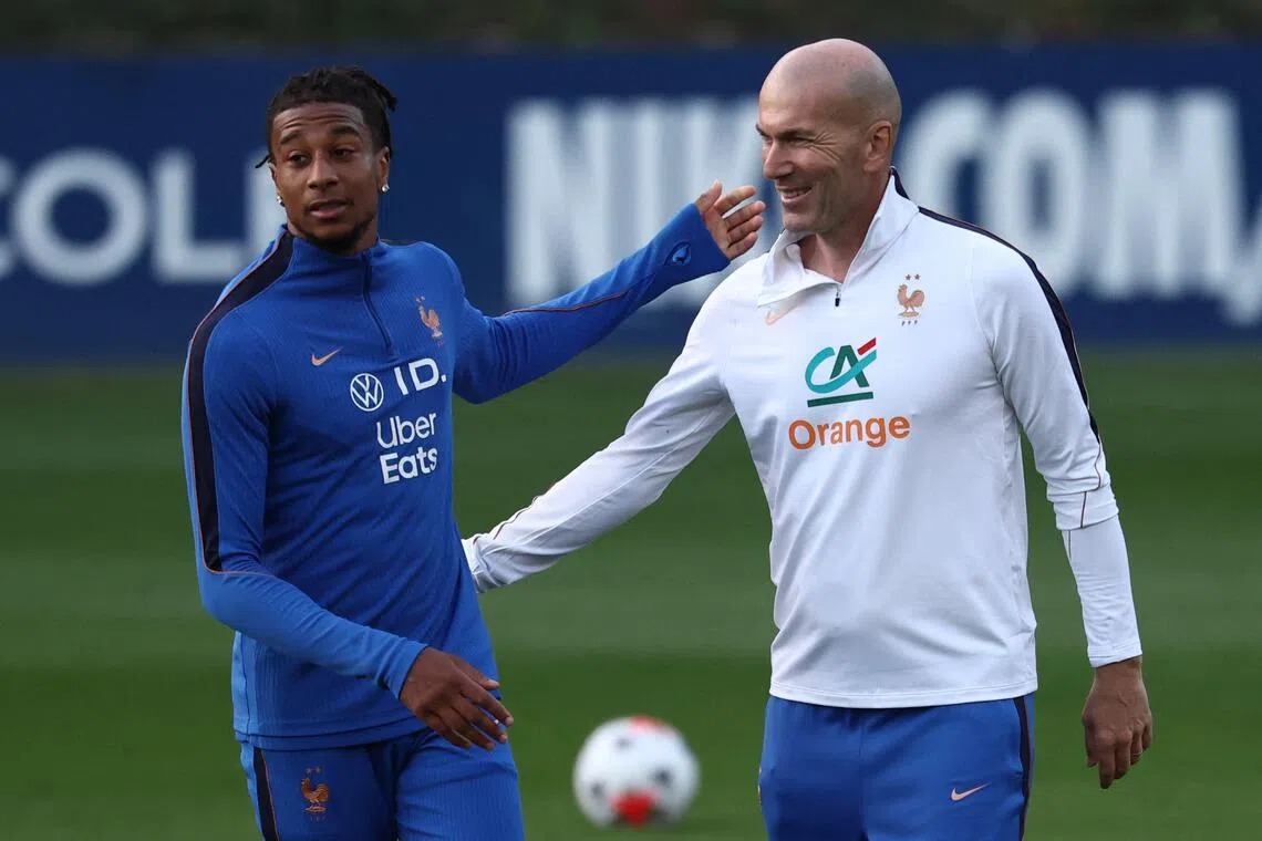 France’s coach Zinedine Zidane (right) and Michael Olise during a training session in Clairefontaine-en-Yvelines, outside Paris, on Sept 21.