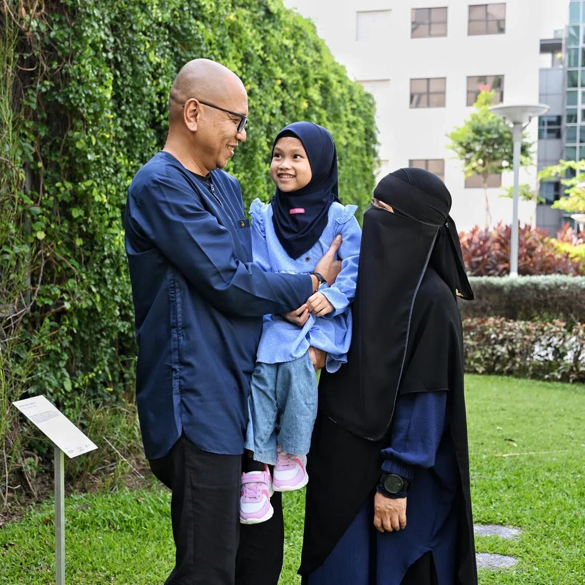 Siti Abdullah (right) with her husband Abdul Rahman and their daughter Sumayyah, who was born without skin on nearly 40 per cent of her body.