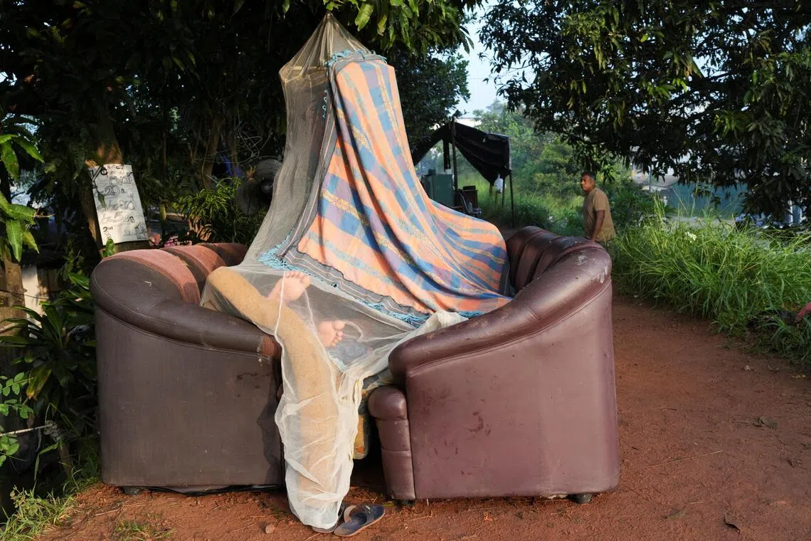 A person sleeps inside a makeshift tent made by a mosquito net and sofas along the banks of Kelani River, following Cyclone Ditwah in Peliyagoda, Sri Lanka, December 1, 2025. REUTERS/Thilina Kaluthotage 