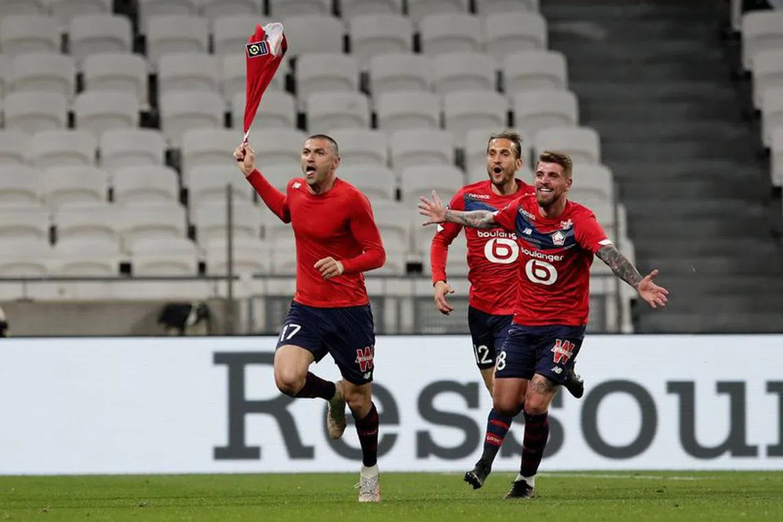 Soccer Football - Ligue 1 - Olympique Lyonnais v Lille - Groupama Stadium, Lyon, France - April 25, 2021 Lille's Burak Yilmaz celebrates scoring their third goal with teammates REUTERS/Benoit Tessier
