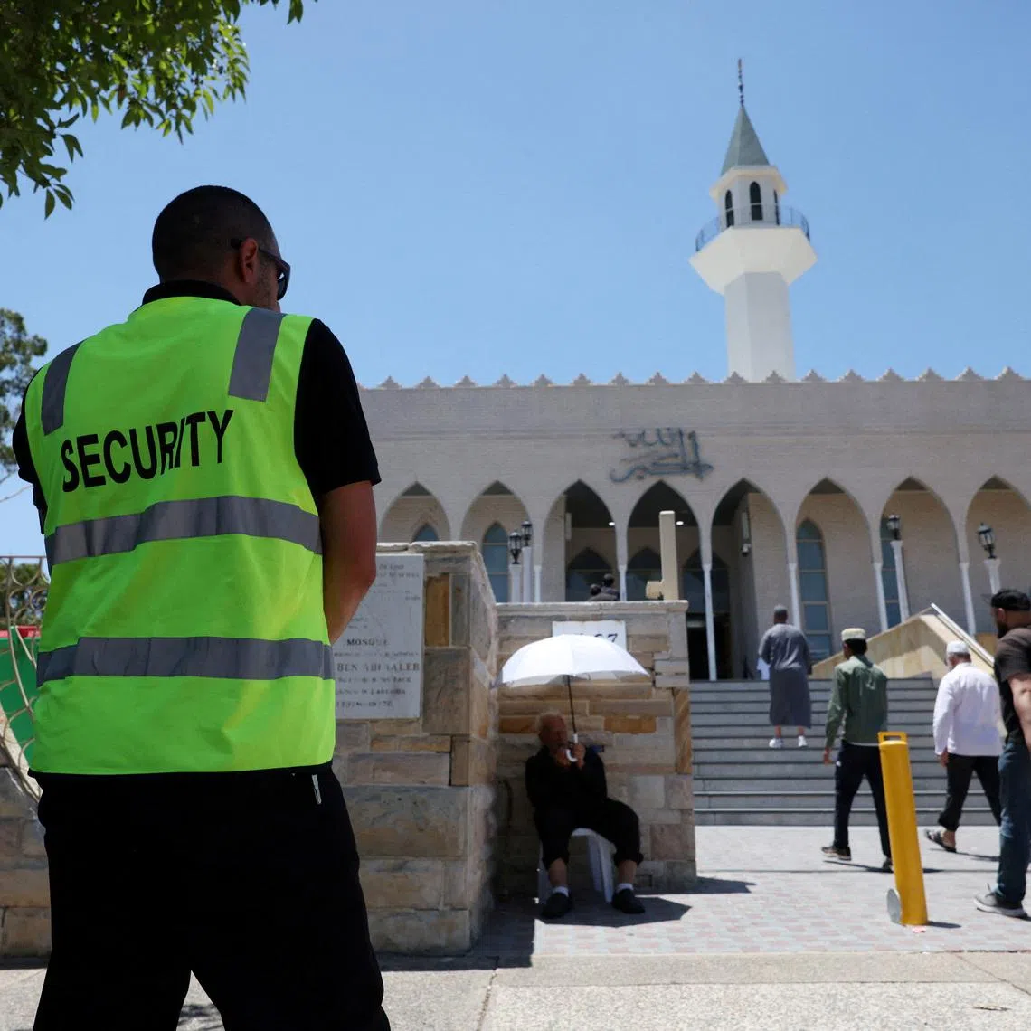 FILE PHOTO: A security guard stands outside the Lakemba Imam Ali bin Abi Talib Mosque as people arrive for Friday prayers, amid a heightened security presence following the deadly mass shooting during a Jewish Hanukkah celebration at Bondi Beach on December 14, in Sydney, Australia, December 19, 2025. REUTERS/Hollie Adams/File Photo
