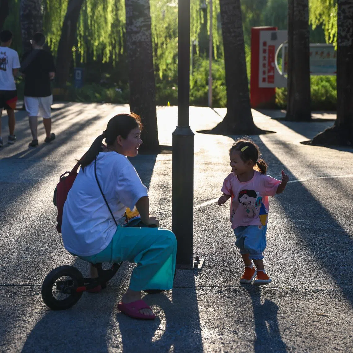 epa12272513 A woman plays with a child in a park in Beijing, China, 30 July 2025. On July 30, China’s Ministry of Finance announced that it will allocate 90 billion yuan (10.85 billion euros) for the initial budget of childcare subsidy payments in 2025.  EPA/WU HAO