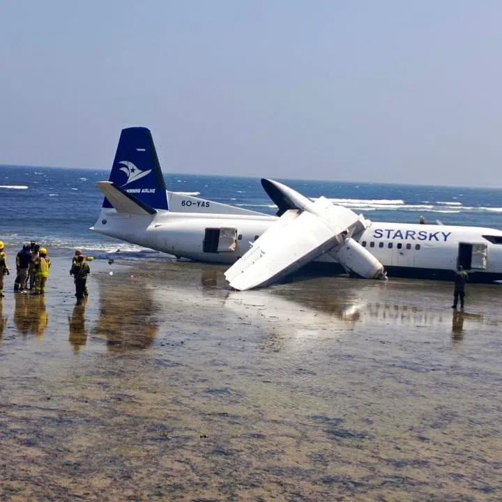Rescuers stand near a plane that crashed on the seashore in Mogadishu, Somalia, February 10, 2026. AUSSOM/Handout via REUTERS