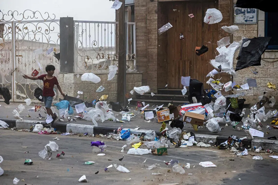 Rubbish blows around in the wind amid a sandstorm in Gaza City on June 1, 2023. 