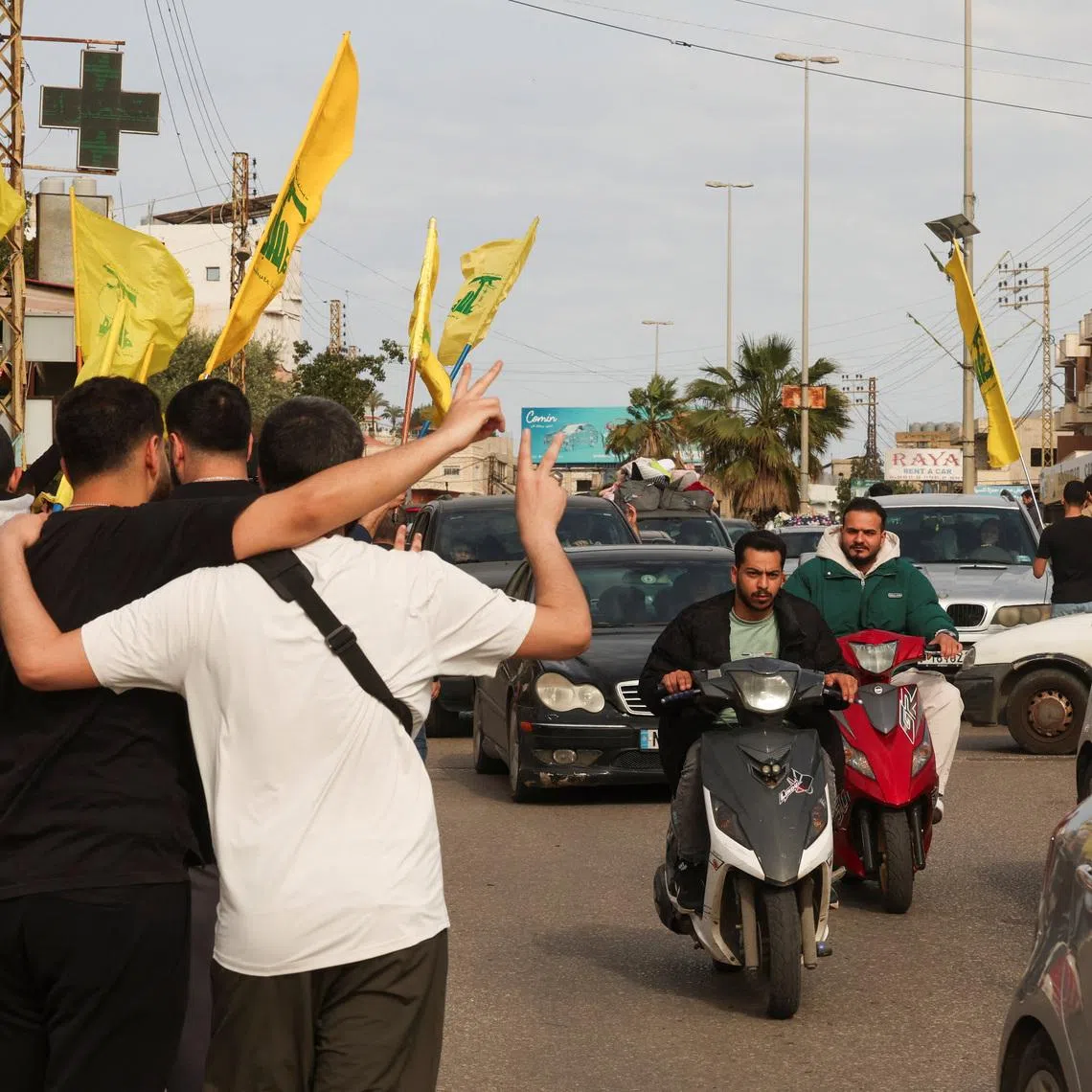 Bystanders flash the victory sign and wave Hezbollah flags as displaced people return to their homes, after a 10-day ceasefire between Lebanon and Israel went into effect, near Nabatieh, Lebanon, April 17, 2026.