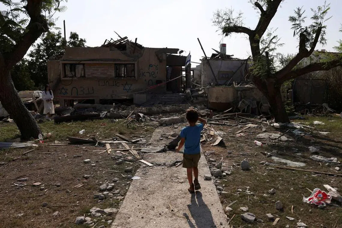 A child looks at a house hit by a rocket fired from the Gaza Strip, in central Israel, amid the ongoing conflict between Israel and the Palestinian Islamist group Hamas, in central Israel, November 3, 2023. REUTERS/Ronen Zvulun/File Photo