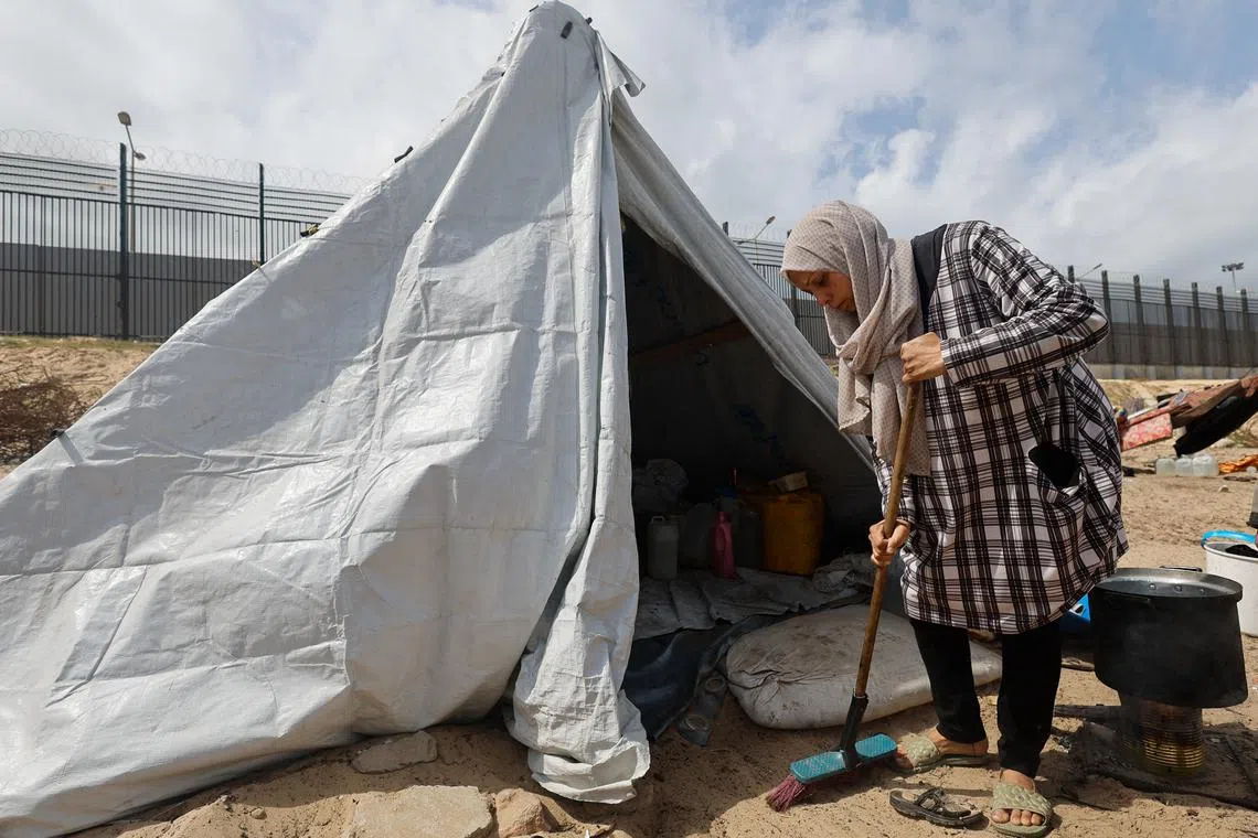 A woman sweeps next to a tent, as displaced Palestinians, who fled their houses due to Israeli strikes shelter in a tent camp, amid the ongoing conflict between Israel and the Palestinian Islamist group Hamas, in Rafah in the southern Gaza Strip, March 6, 2024. REUTERS/Mohammed Salem/ File photo