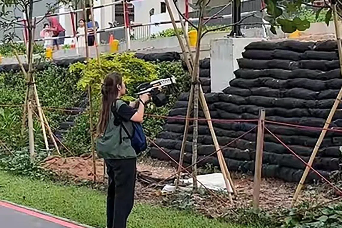 An NParks contractor using water gel blasters to drive the monkeys out of a HDB estate in Punggol on Aug 2.