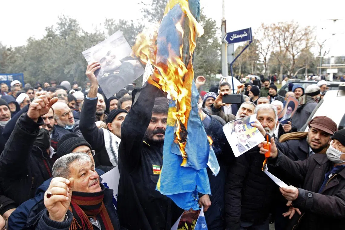 Iranians burn a Swedish flag during a protest in Teheran against the burning of a Quran in Stockholm by a far-right politician.