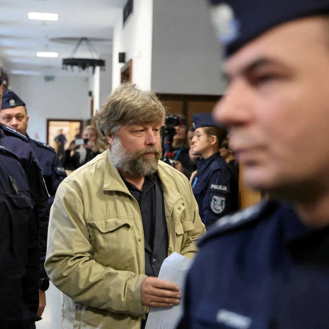FILE PHOTO: Russian archaeologist Alexander Butyagin, who is accused by Ukraine of unauthorised excavation and plundering of historical artefacts in Crimea, is escorted by Polish police as he arrives at a district court in Warsaw, Poland, January 15, 2026. Robert Kowalewski/Agencja Wyborcza.pl via REUTERS