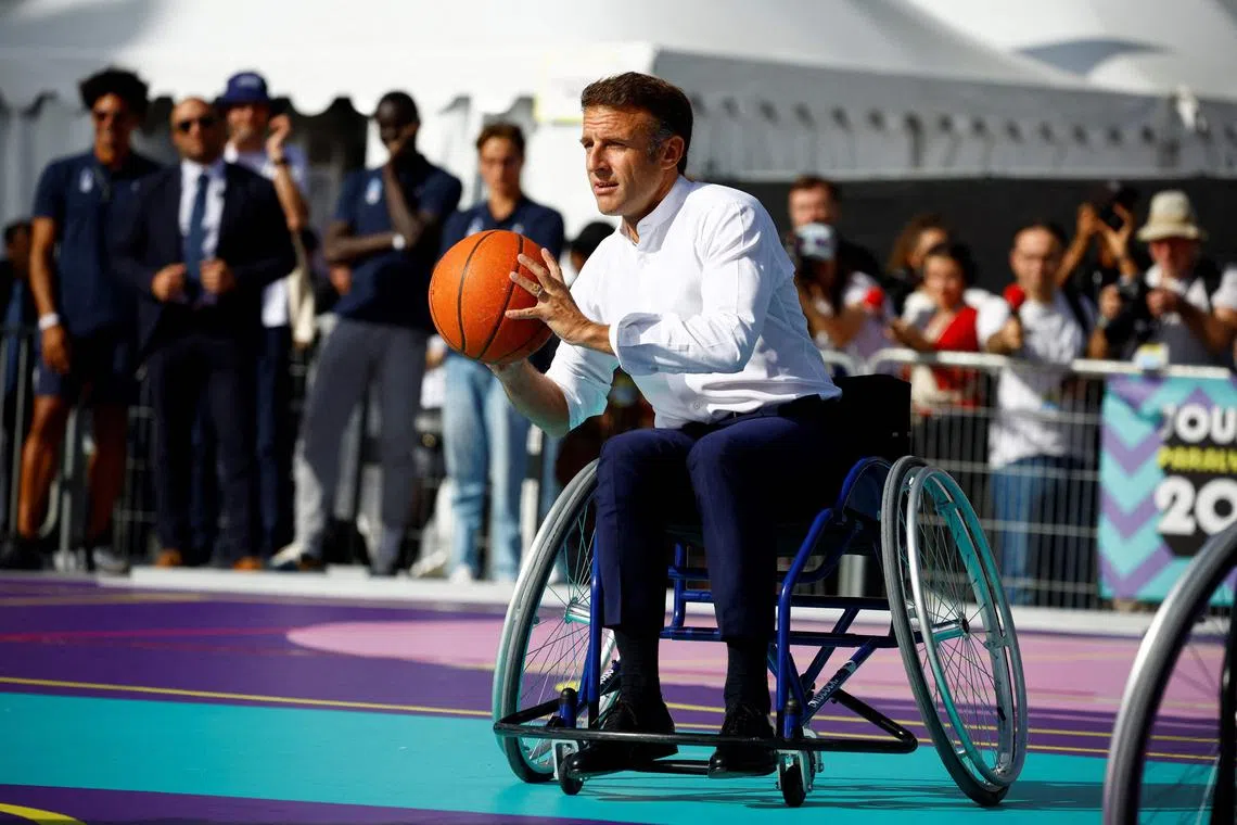 French President Emmanuel Macron playing basketball with Paralympic athletes during the Paralympic Day at Place de la Republique, in Paris, on Sunday.