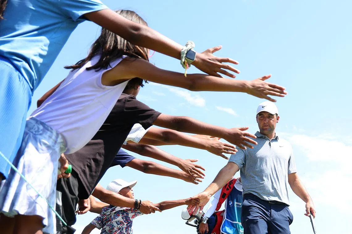 Scottie Scheffler of the United States greets fans on the sixth hole during the third round of the BMW Championship at Olympia Fields Country Club on Aug 19.
