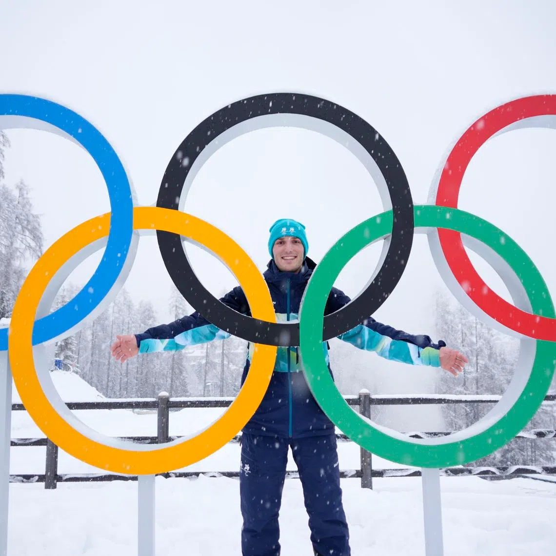 Feb 4, 2026; Cortina d'Ampezzo, ITALY; Cesare Marchedde of Balogna Italy poses for a photo in front of Olympic rings ahead of the Milano Cortina 2026 Olympic Winter Games at the Cortina Sliding Centre. Mandatory Credit: Michael Madrid-Imagn Images