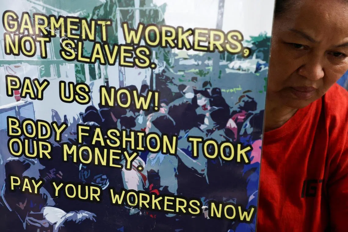 A Thai worker holds a banner during a protest of workers from three textile factories that they say were closed in 2023.