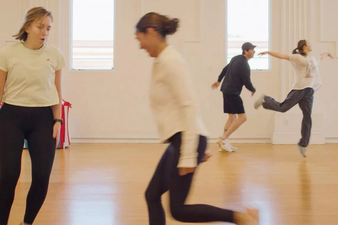Students of Clown Cardio class begin with a warm-up activity where each person tries to tag his or her partner’s back while attempting to do a dance together.