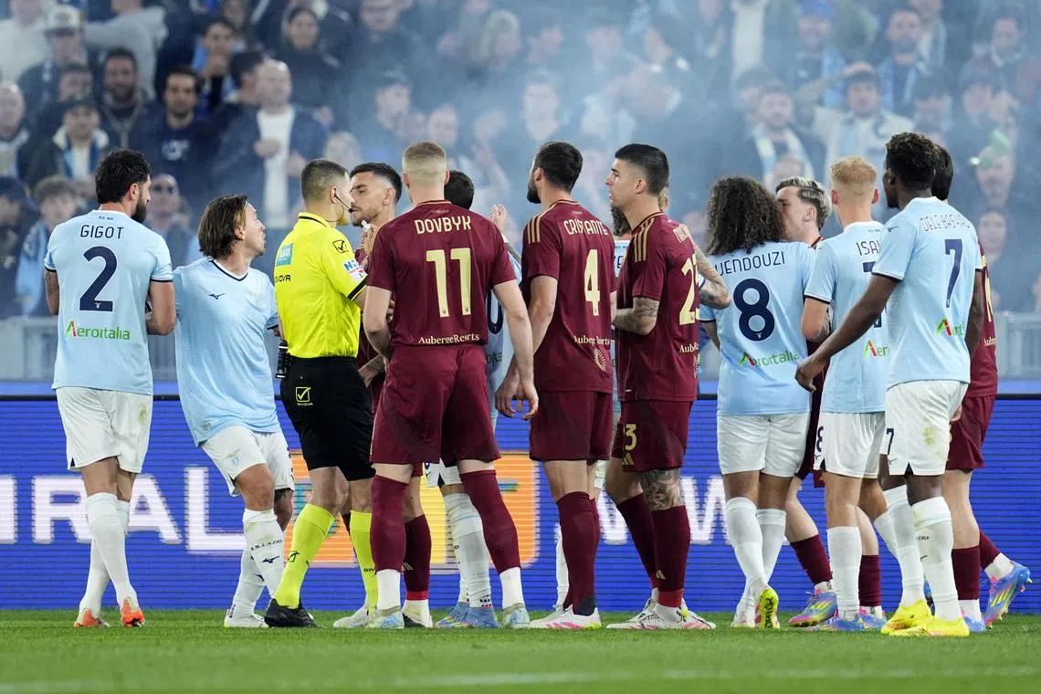 Lazio and AS Roma players clashing during their Serie A match at Rome's Stadio Olimpico on April 13, 2025.