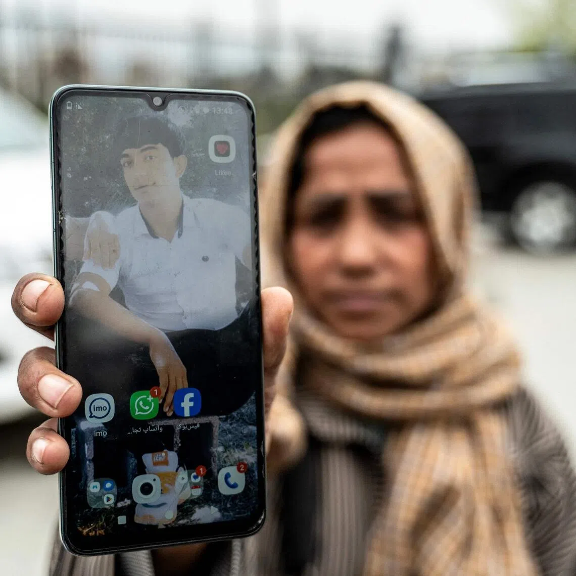 Afghan woman Samira Muhammadi showing a photograph of her son, Mr Aref Khan, who was killed by a Pakistani air strike that struck a drug rehabilitation centre.