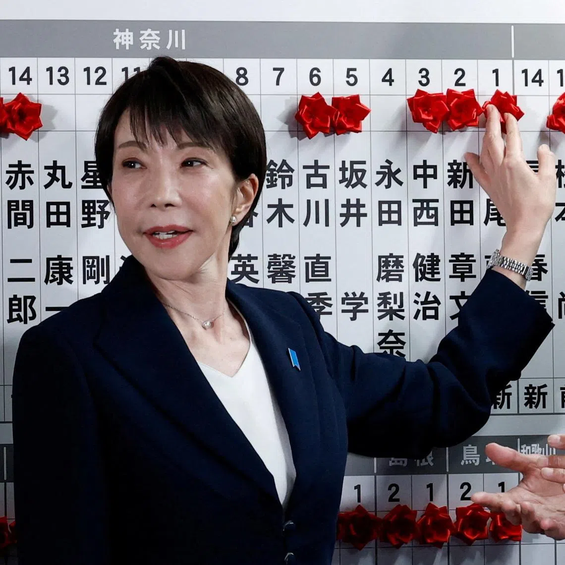 Japan's Prime Minister Sanae Takaichi, leader of the ruling Liberal Democratic Party (LDP), places a red paper rose on the name of an elected candidate at the LDP headquarters on general election day in Tokyo, Japan, February 8, 2026. REUTERS/Kim Kyung-Hoon/Pool