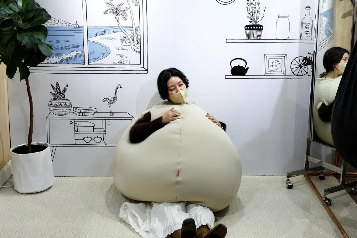 Yuu Matsuzaki, a product buyer for the Marui Group tries on the wearable beanbag during a photo opportunity at a pop-up booth of the Shinjuku Marui main department store in Tokyo, Japan Feb 6, 2023. While the beanbag's onion-shaped goofy style made it a hit on Japanese social media earlier this month, the main goal was relaxation, according to Shogo Takikawa, a representative of the beanbag's manufacturer, Takikou Sewing. 