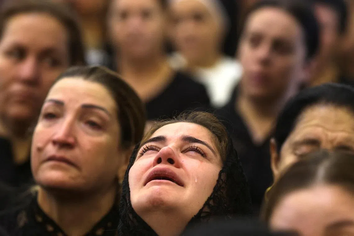 An Iraqi Christian reacting as she attends a mass following a fatal fire at a wedding celebration, at the Grand Immaculate Church, in Hamdaniya, Iraq Sept 28.